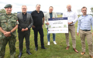 Stuurgroepleden staan in veld bij Energiehub Eeserwold