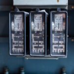 Drie oude elektrische meters van Brown Boveri naast elkaar op een paneel